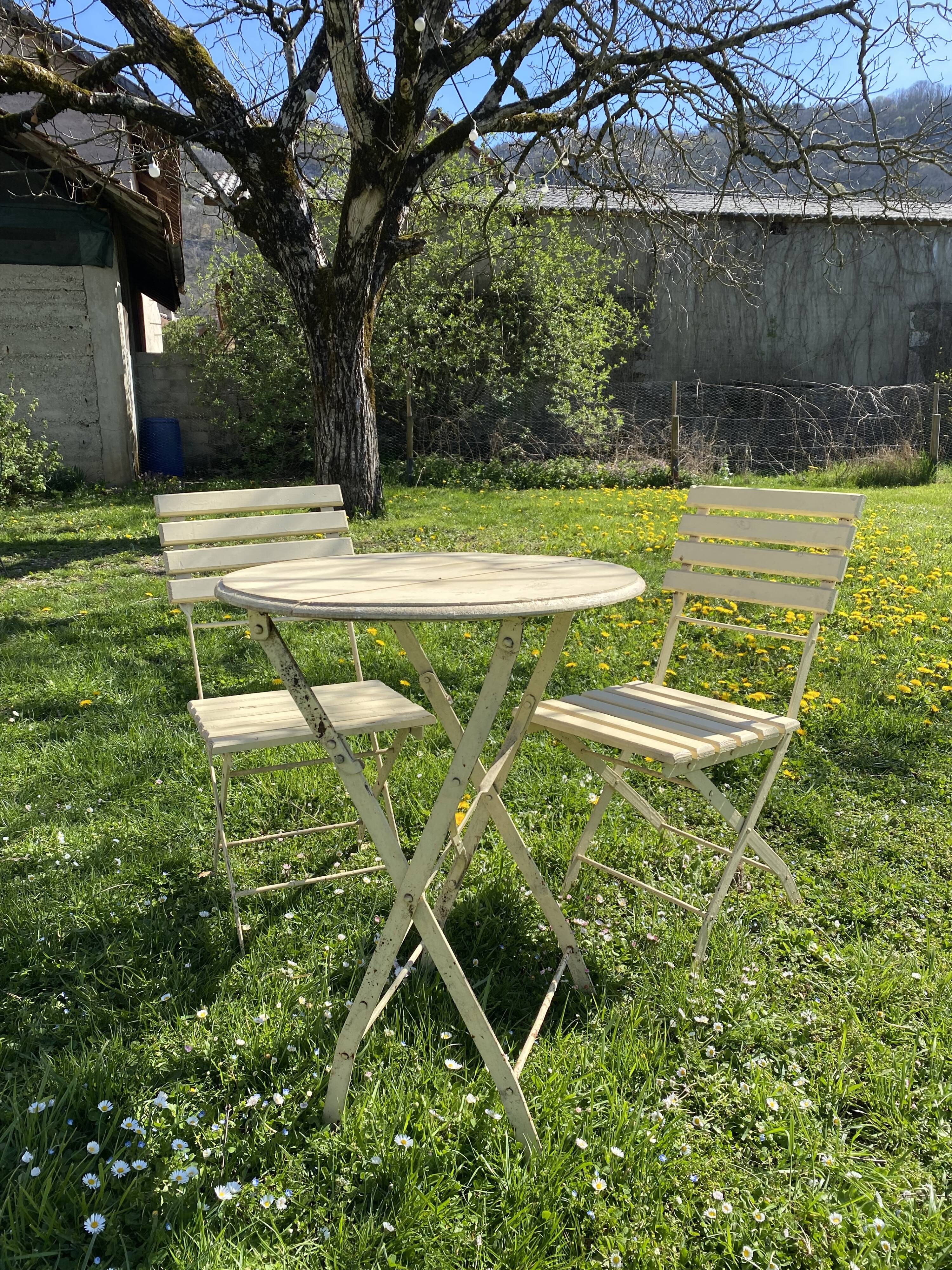 Table et 2 chaises de jardin en métal et bois beige marquées "Bistrot Paris"