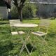 Table et 2 chaises de jardin en métal et bois beige marquées "Bistrot Paris"