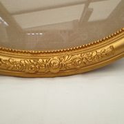 Large old oval gilded wooden frame and stucco decorations