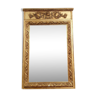 Empire's gilded mirror abounding carved with attributes of the time