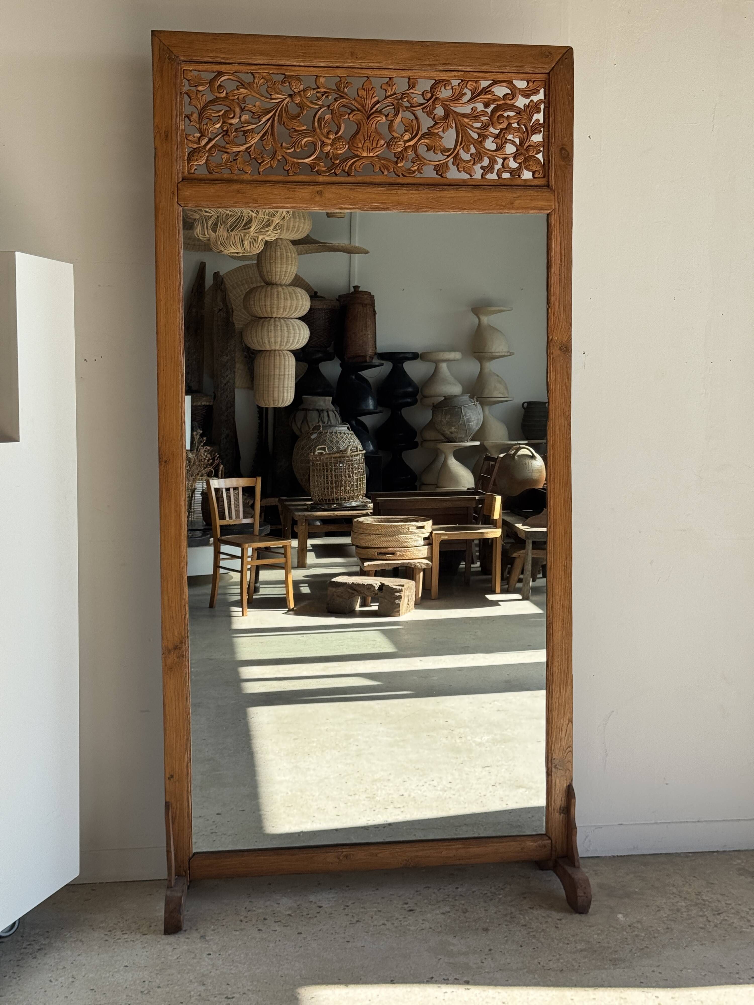 Very large freestanding teak mirror with an openwork carved pediment, Indonesia.