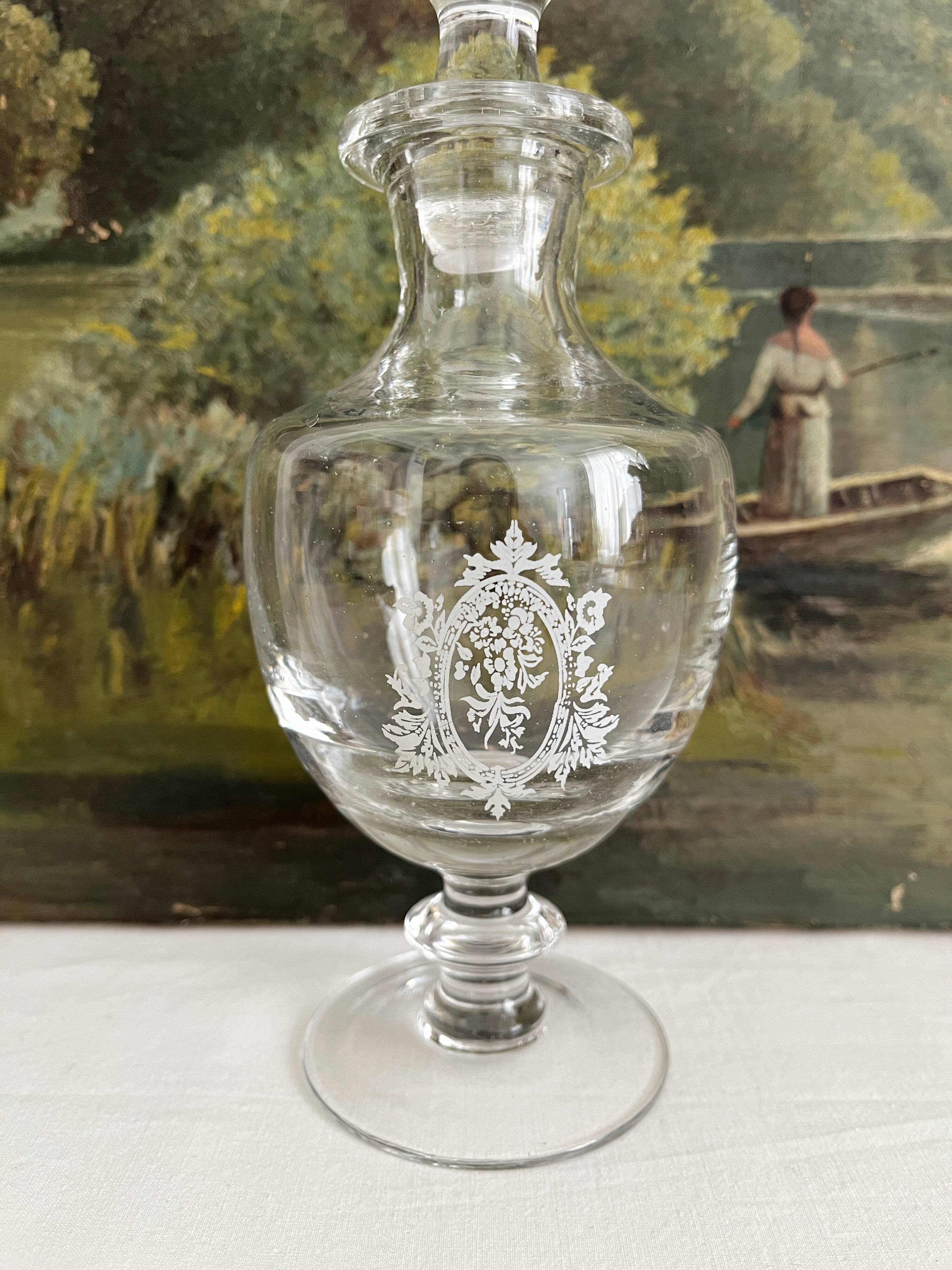 Antique stemmed blown glass bottle with engraved medallion