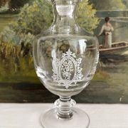 Antique stemmed blown glass bottle with engraved medallion