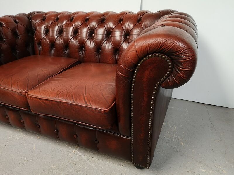 Two-seater brown leather chesterfield sofa