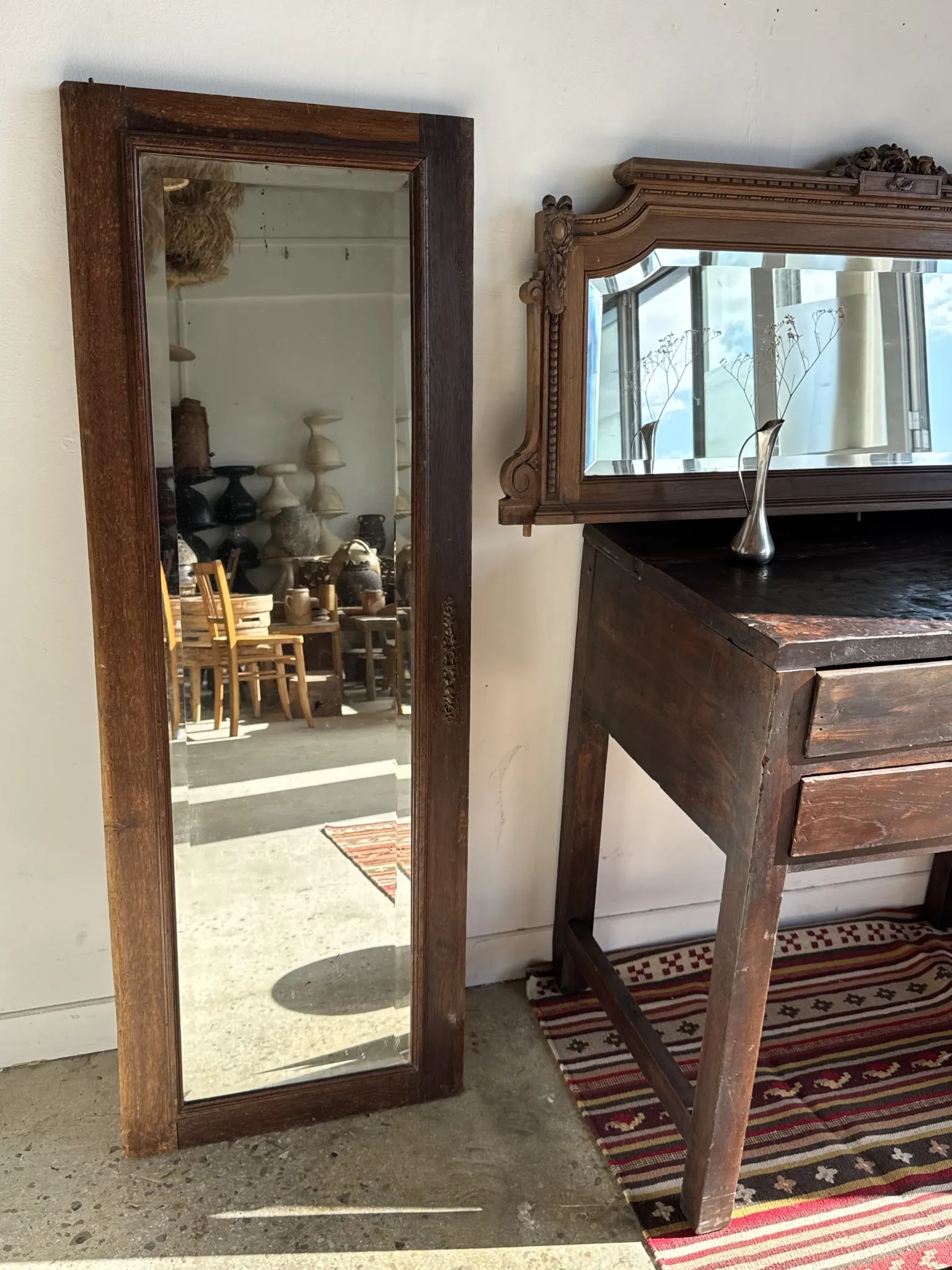 Antique mirror door (left) of a brown oak wardrobe with bevelled glass.