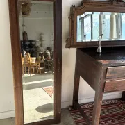 Antique mirror door (left) of a brown oak wardrobe with bevelled glass.