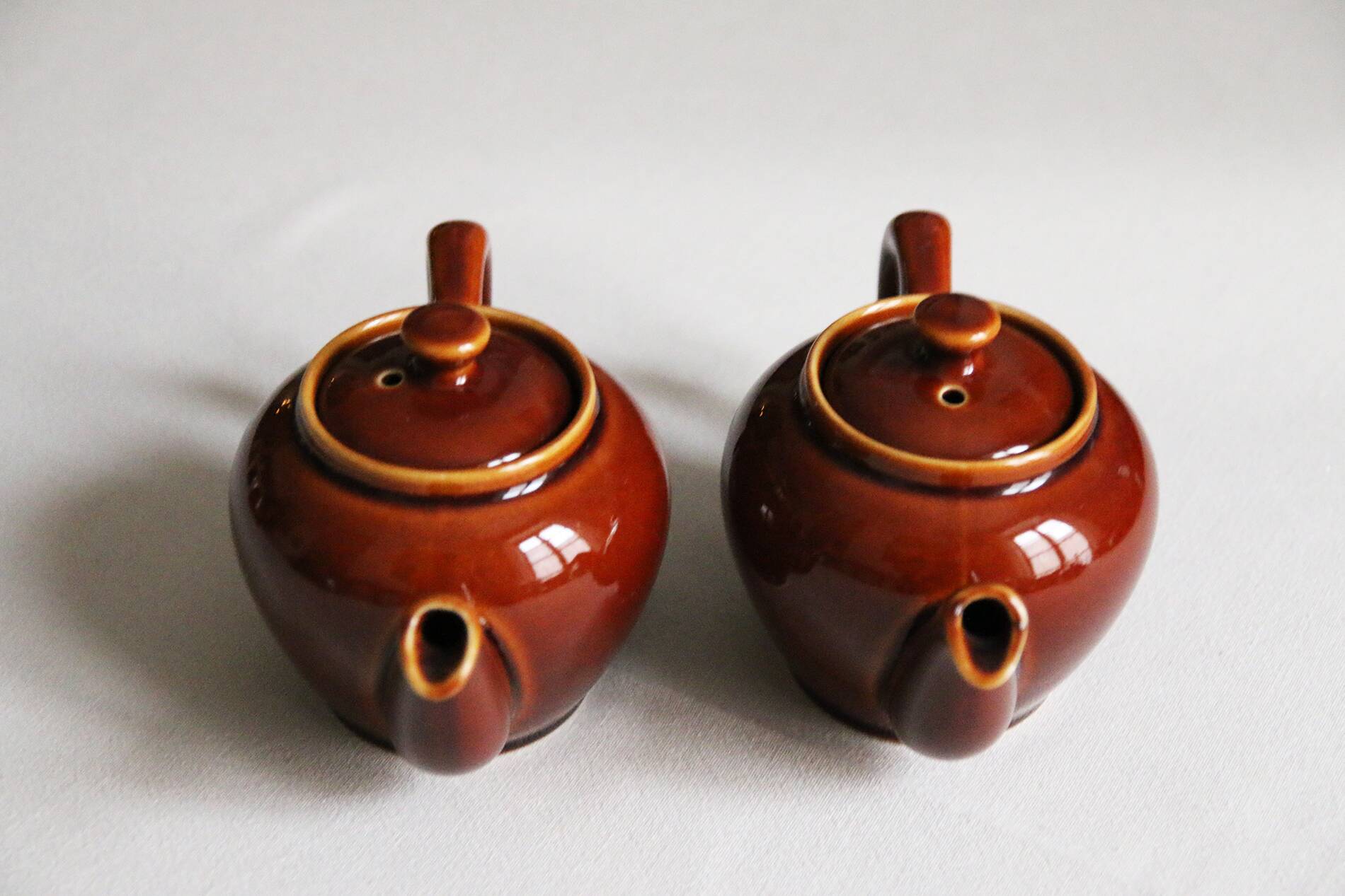 2 brown glazed ceramic teapots