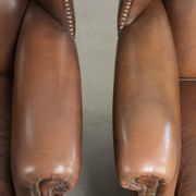 Ensemble de 2 fauteuils à oreilles en cuir de vache de style anglais.