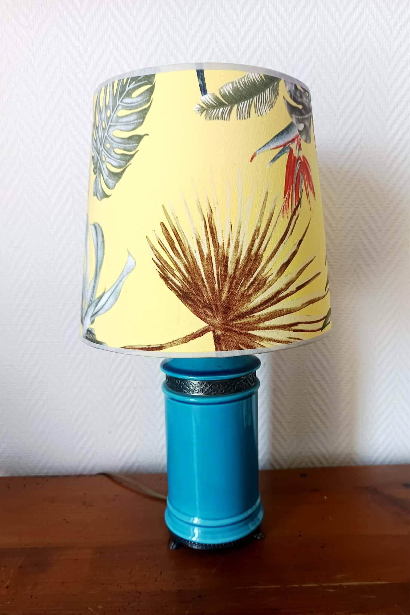 Blue ceramic lamp with claw feet and foliage lampshade.
