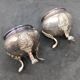 Pair of silver metal salt cellars with lion decor base