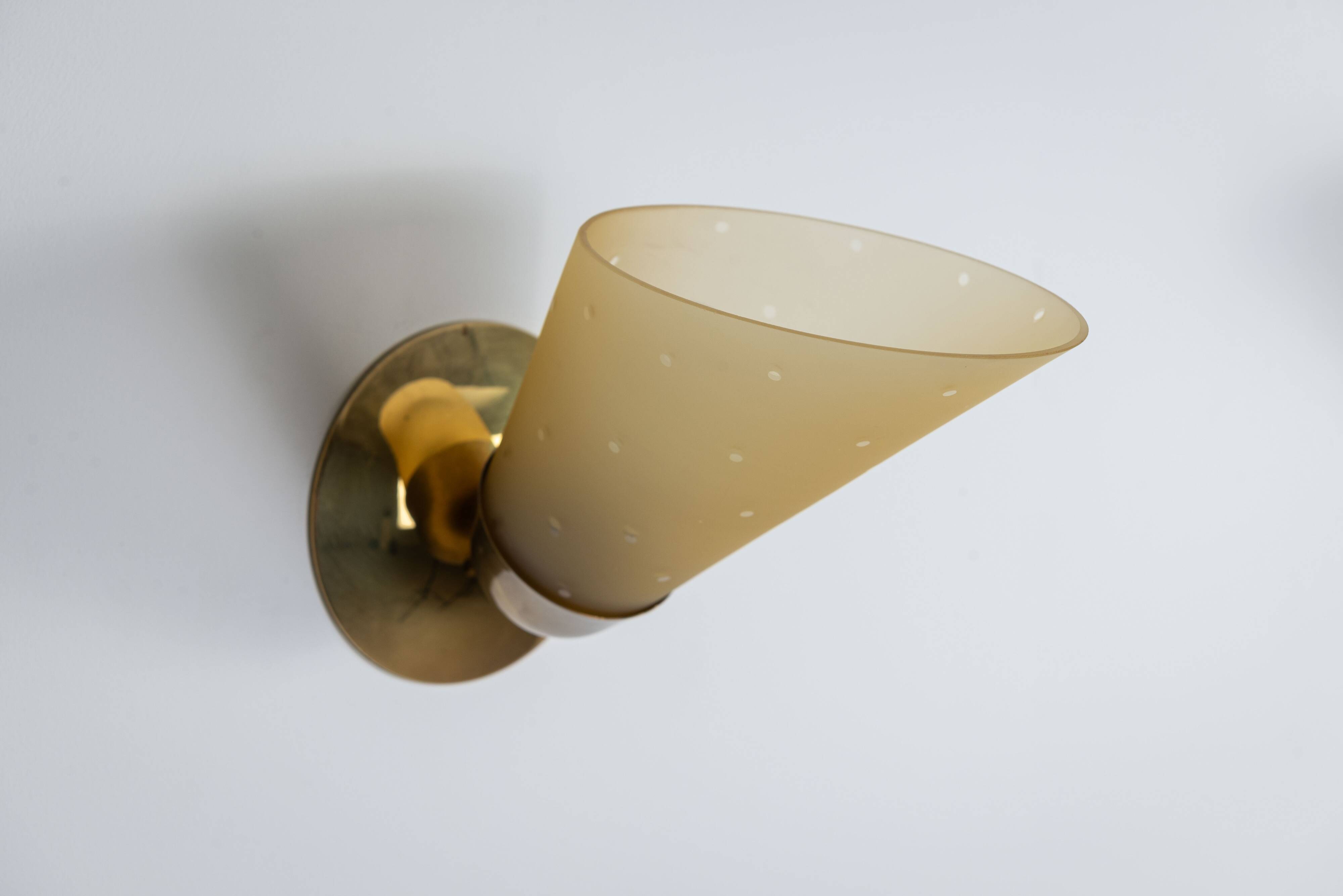 Set of three brass sconces with decorated yellow glass shades