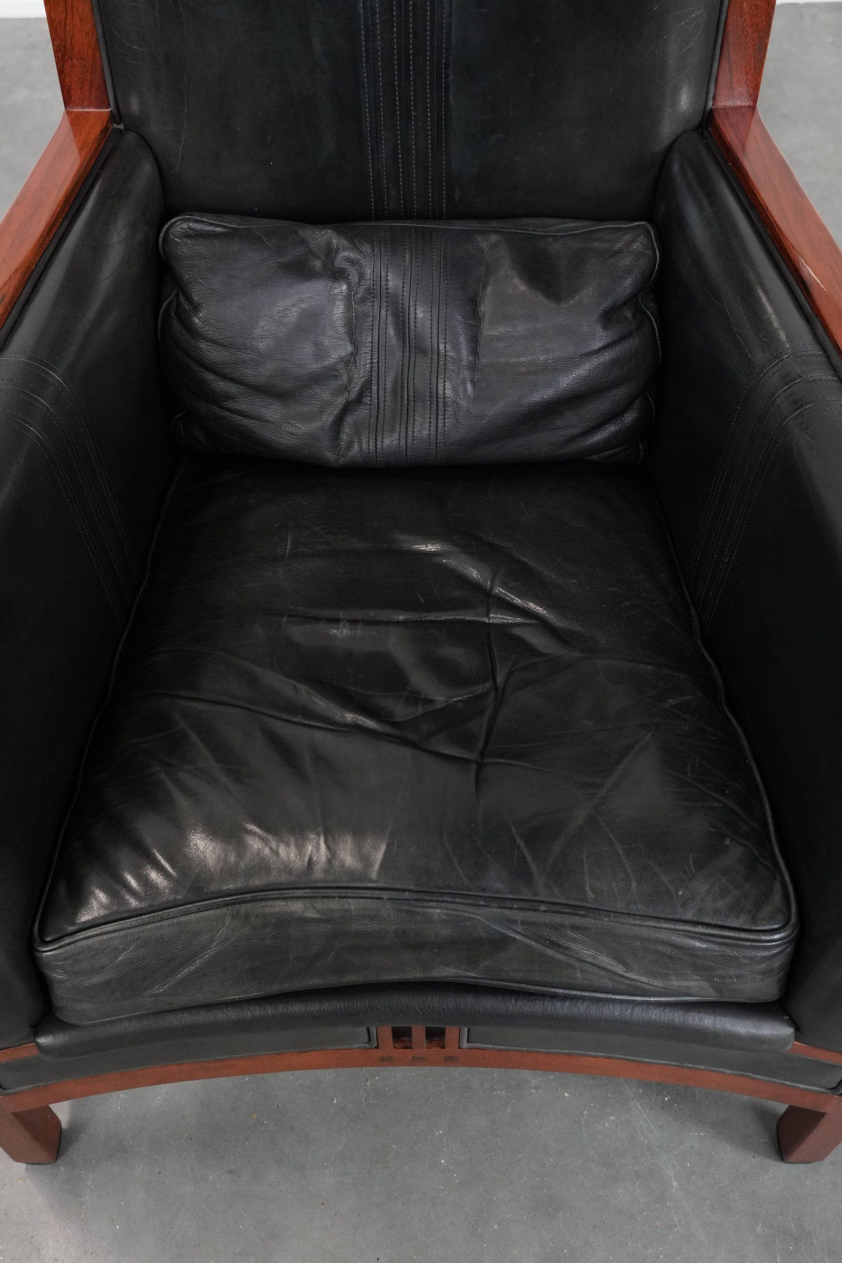 Black cowhide leather and wooden Art Deco design armchair