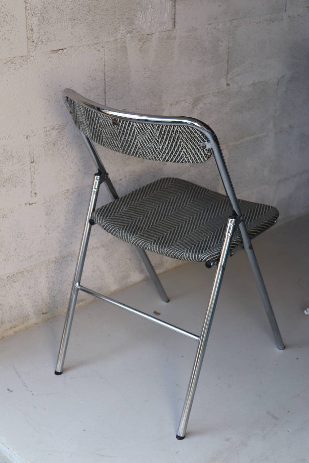 Vintage folding chair in chrome metal and chevron fabric.