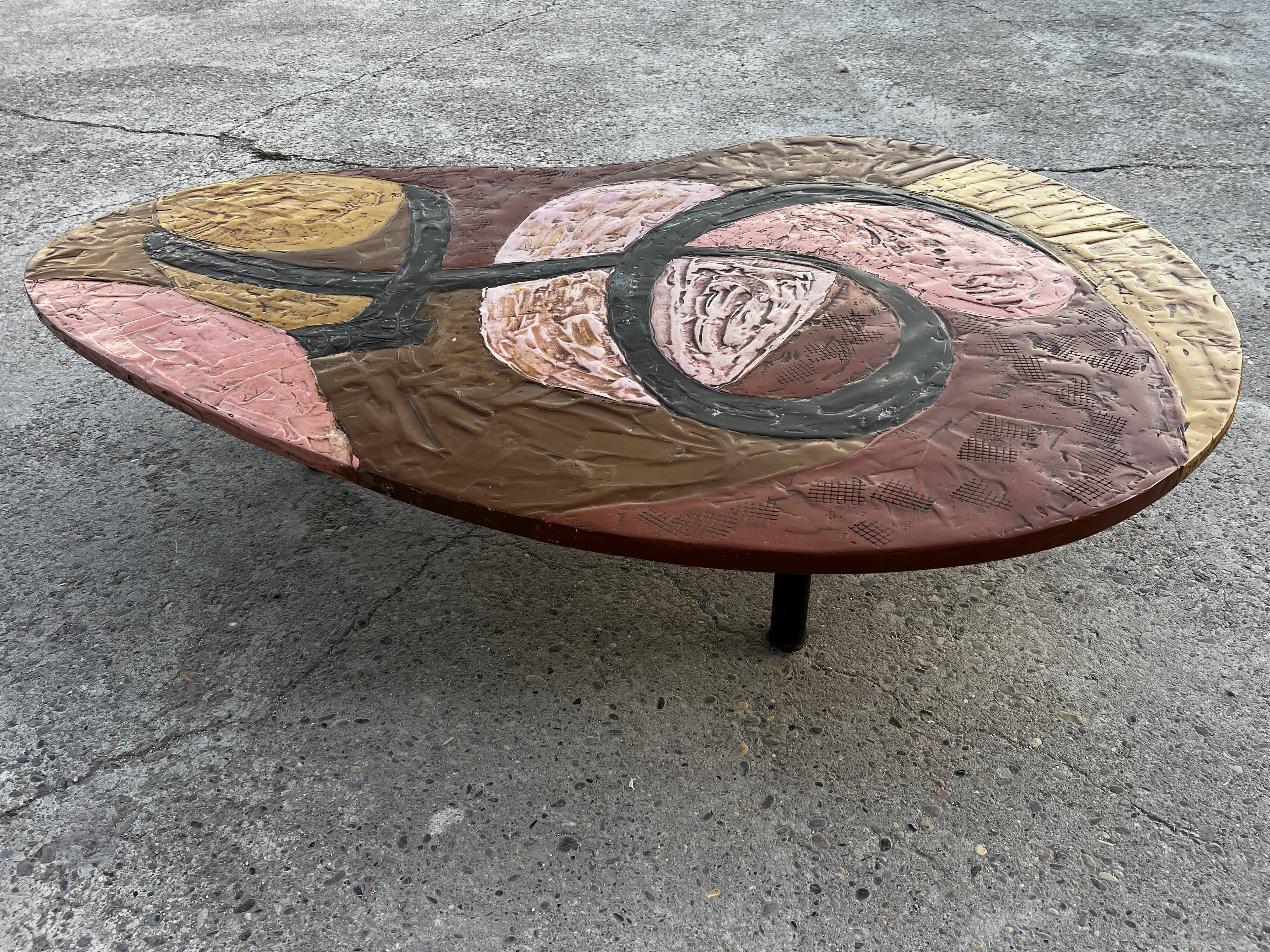 Table basse en résine scarifiée, pieds gainés de cuir marron signé 1960