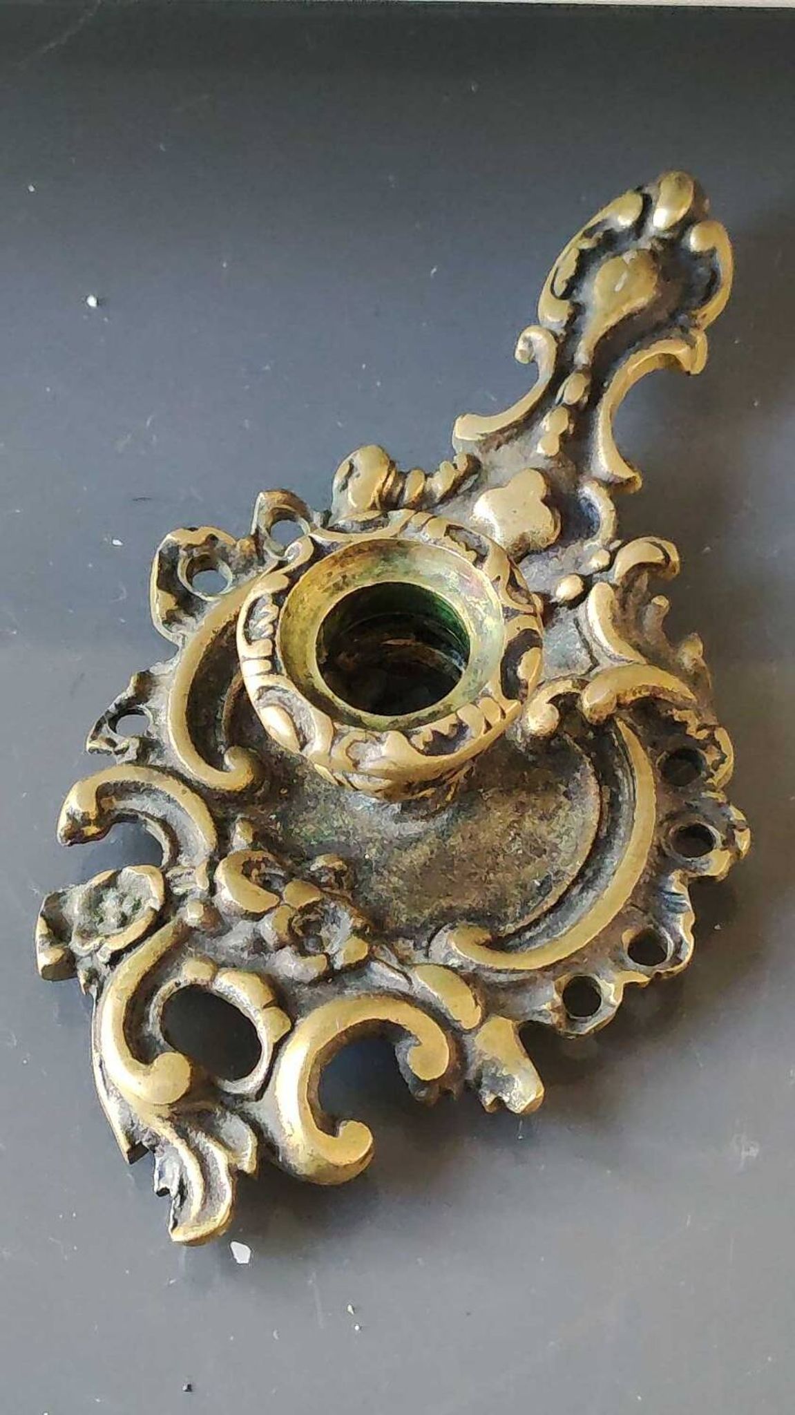Antique Baroque/Rocaille style hand candle holder. In bronze with an old gold patina.