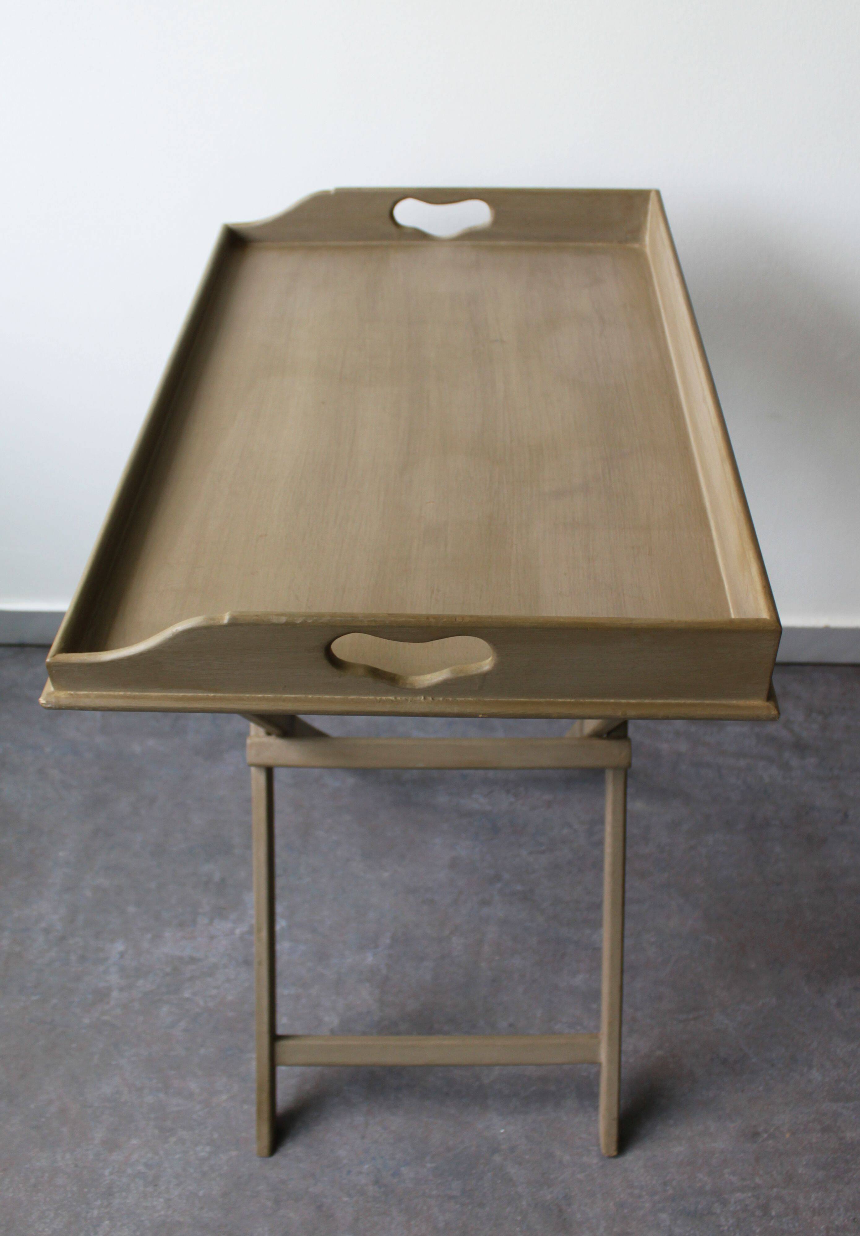 Folding and removable service tray in taupe-painted wood.