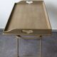 Folding and removable service tray in taupe-painted wood.