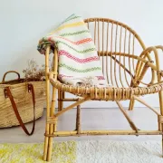 Moroccan plaid made of handwoven wool, decorated with stripes and pom poms.