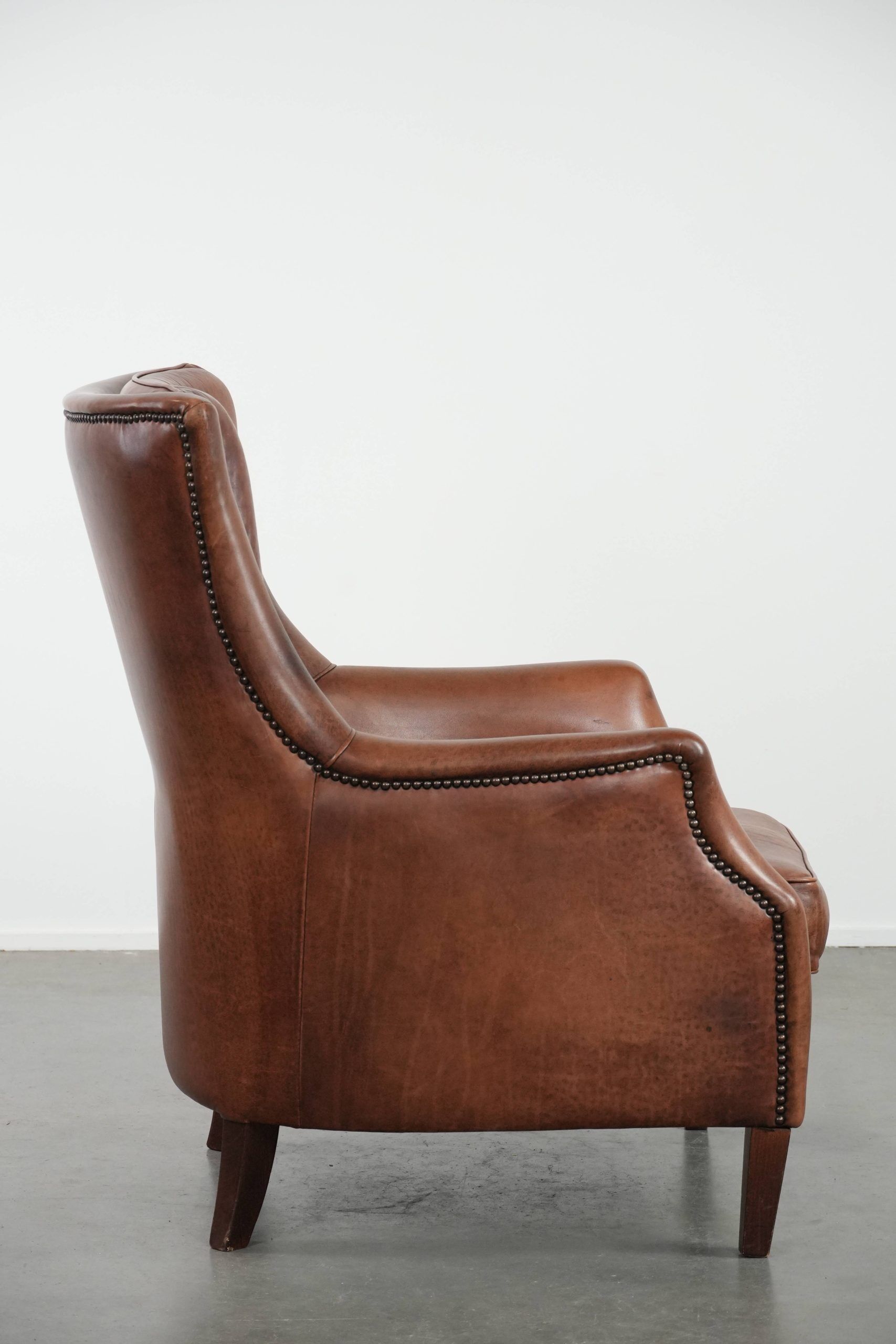 Cognac brown cow leather armchair with decorative nail finish