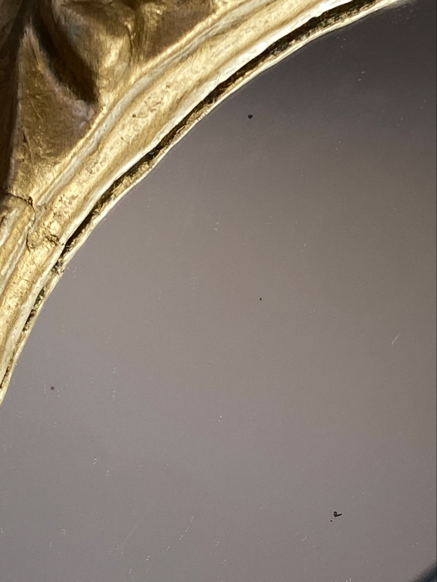 Round wooden mirror in golden colour.