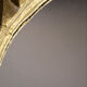 Round wooden mirror in golden colour.