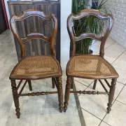 Pair of antique caned and wooden chairs from the 1900s.