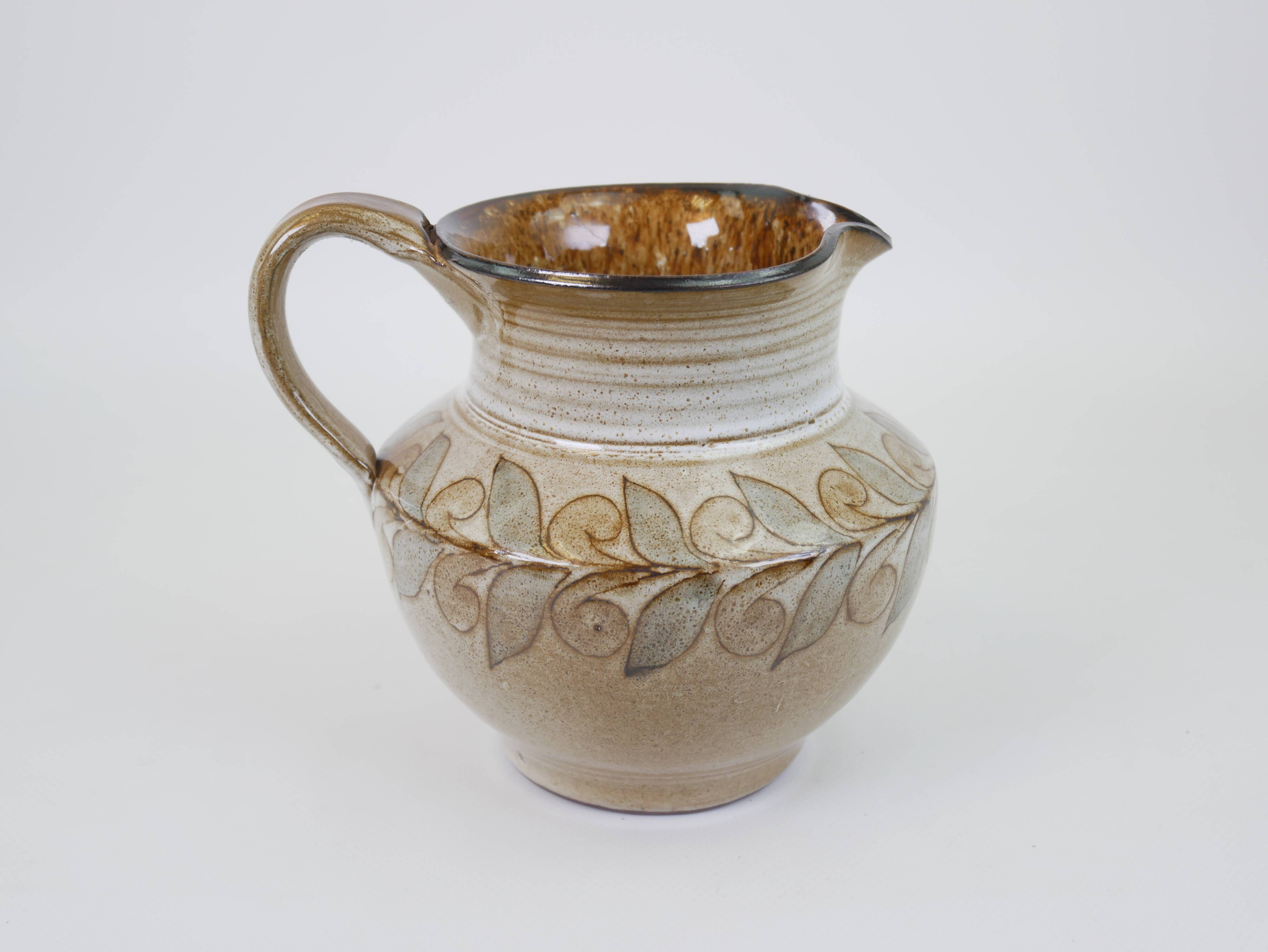 Glazed ceramic jug with plant decoration