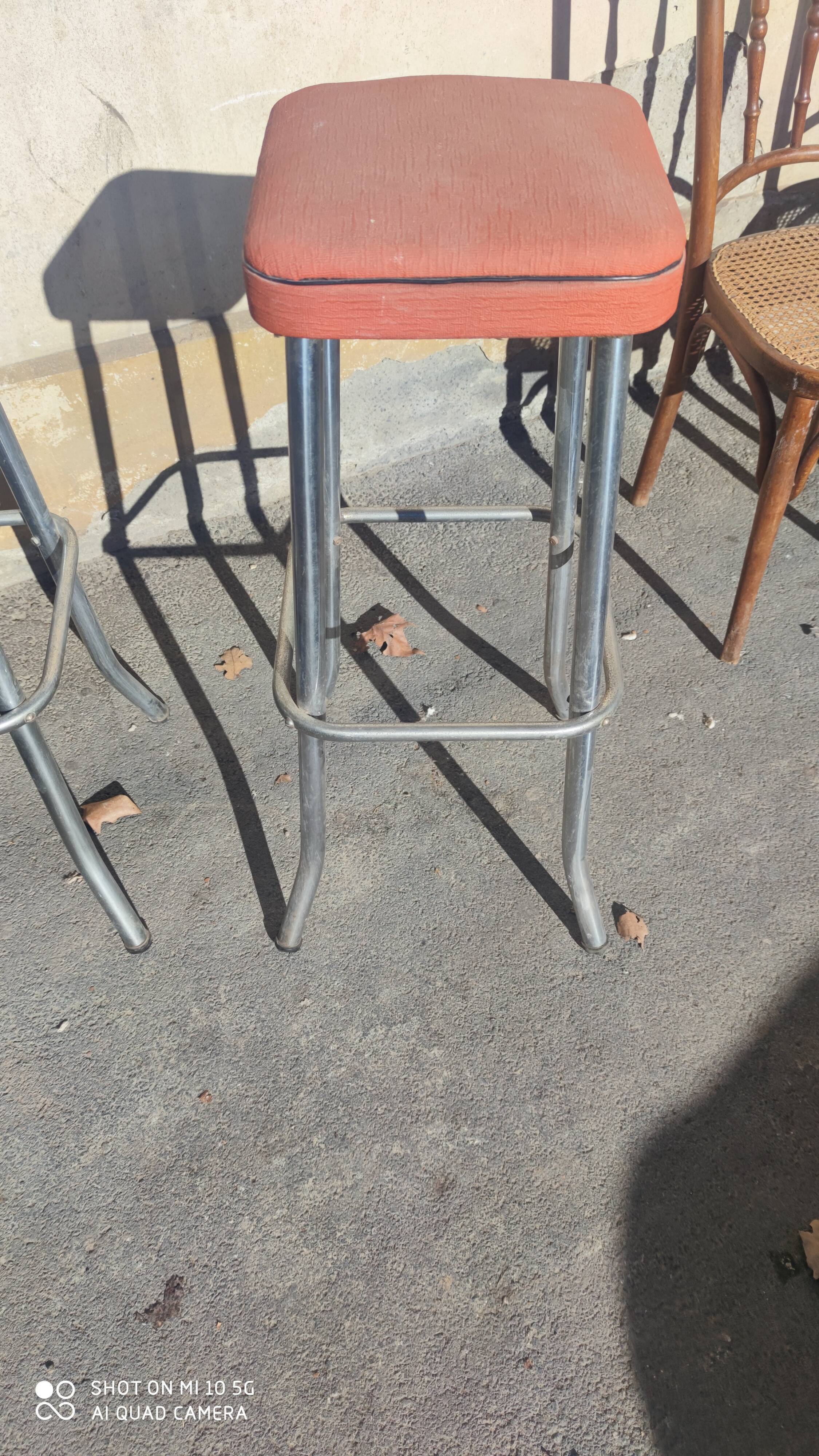 Pair of aluminum bar stools with orange and black seats