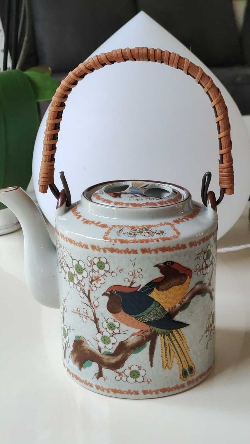 Japanese ceramic teapot. bird/paradise motifs/cherry trees. bamboo/rattan braided handle