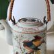 Japanese ceramic teapot. bird/paradise motifs/cherry trees. bamboo/rattan braided handle