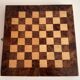 Old wooden chess set with a folding wooden box.