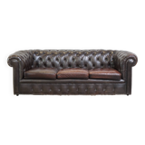 Old dark brown 3-seater cowhide chesterfield sofa with lots of character