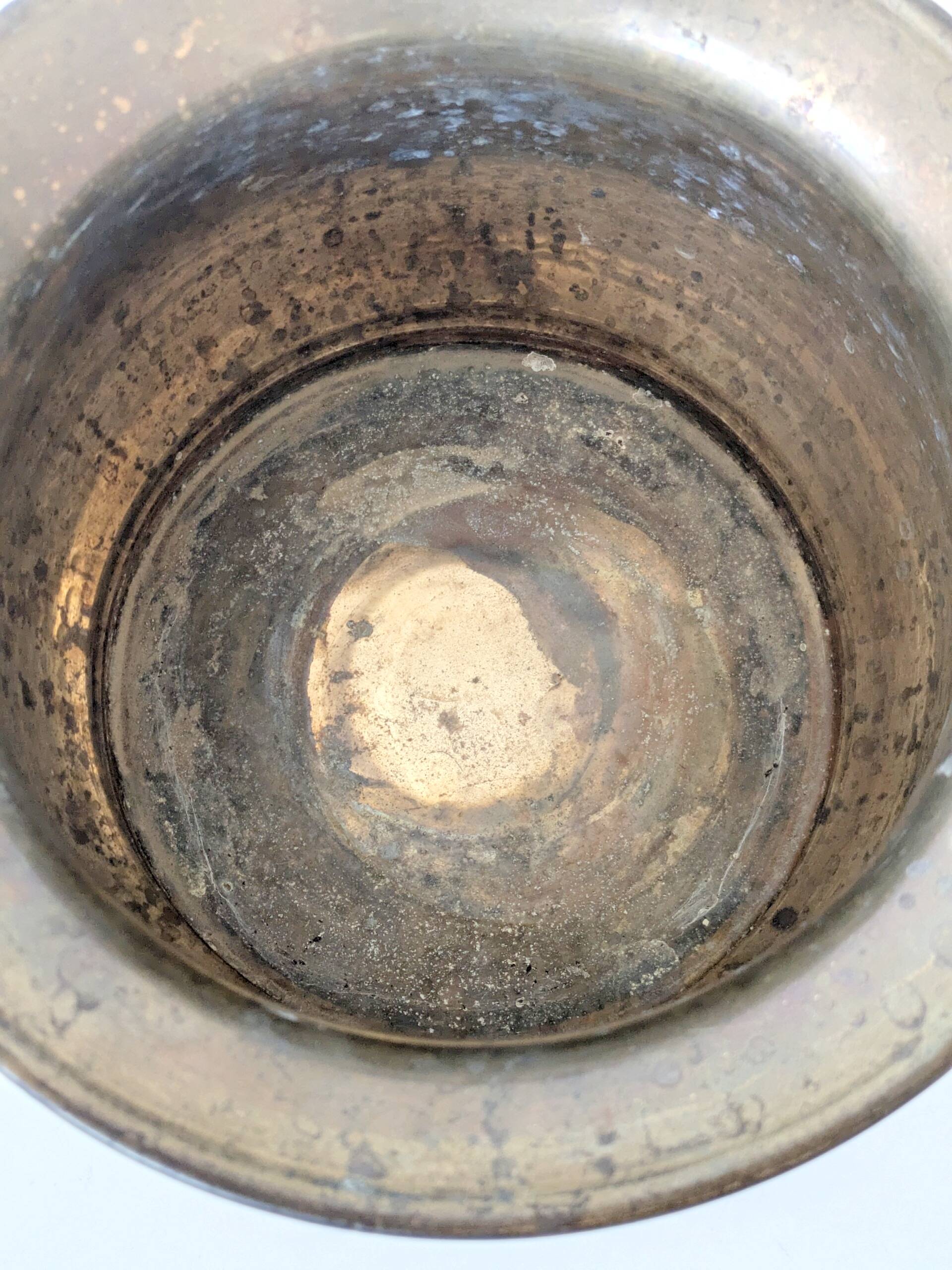 Vintage round cache-pot in hammered brass with decorative handles and patina.