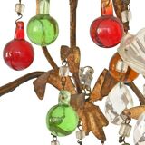 Lustrous chandelier with two wall lights decorated with foliage and pendants.