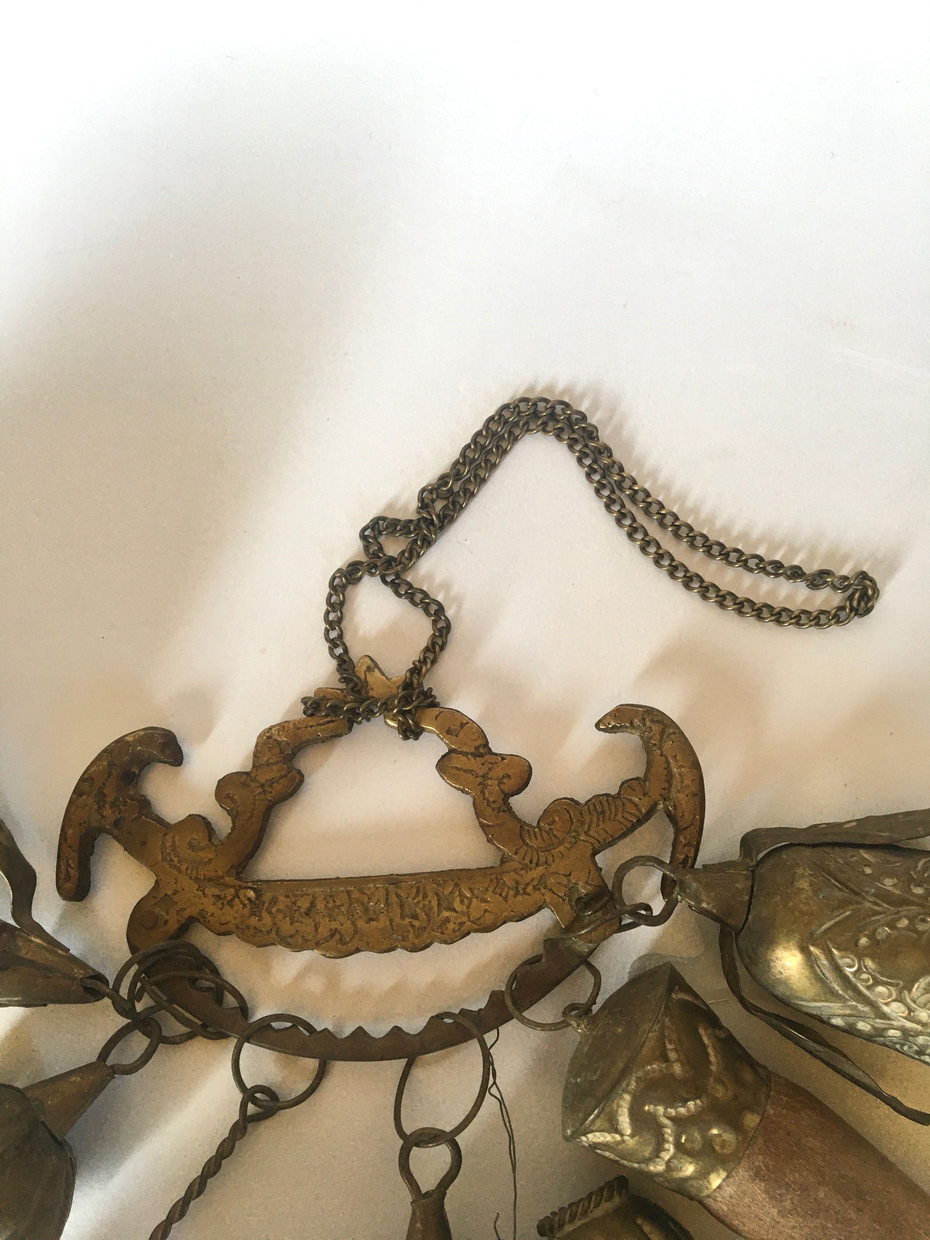 Wall decoration of brass and wood amulets