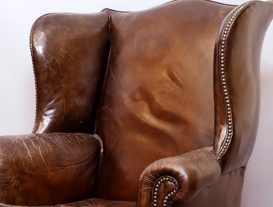 Wingback armchair in dark brown patinated leather, 1970s