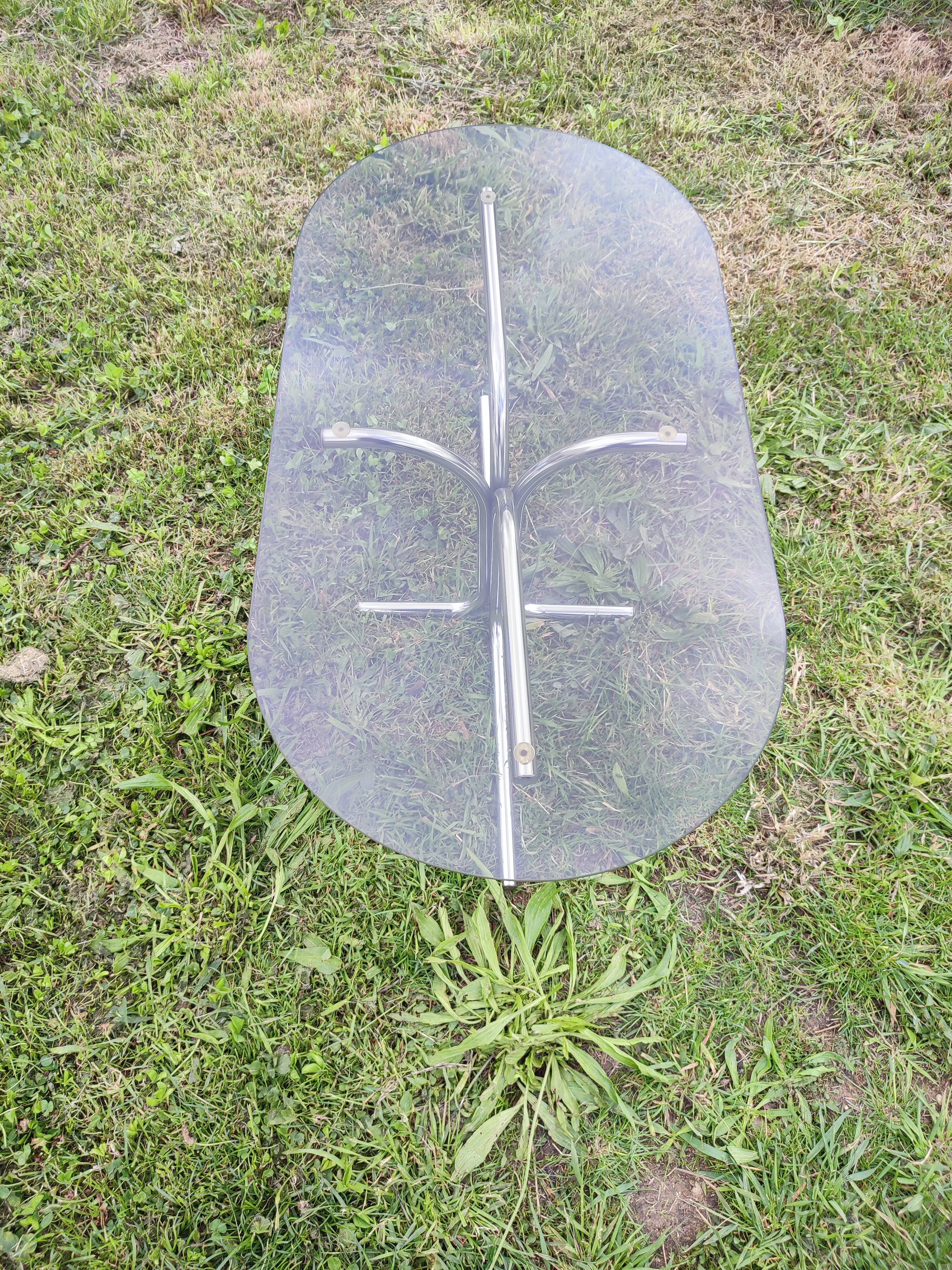 Vintage coffee table with metal tube structure and glass top.