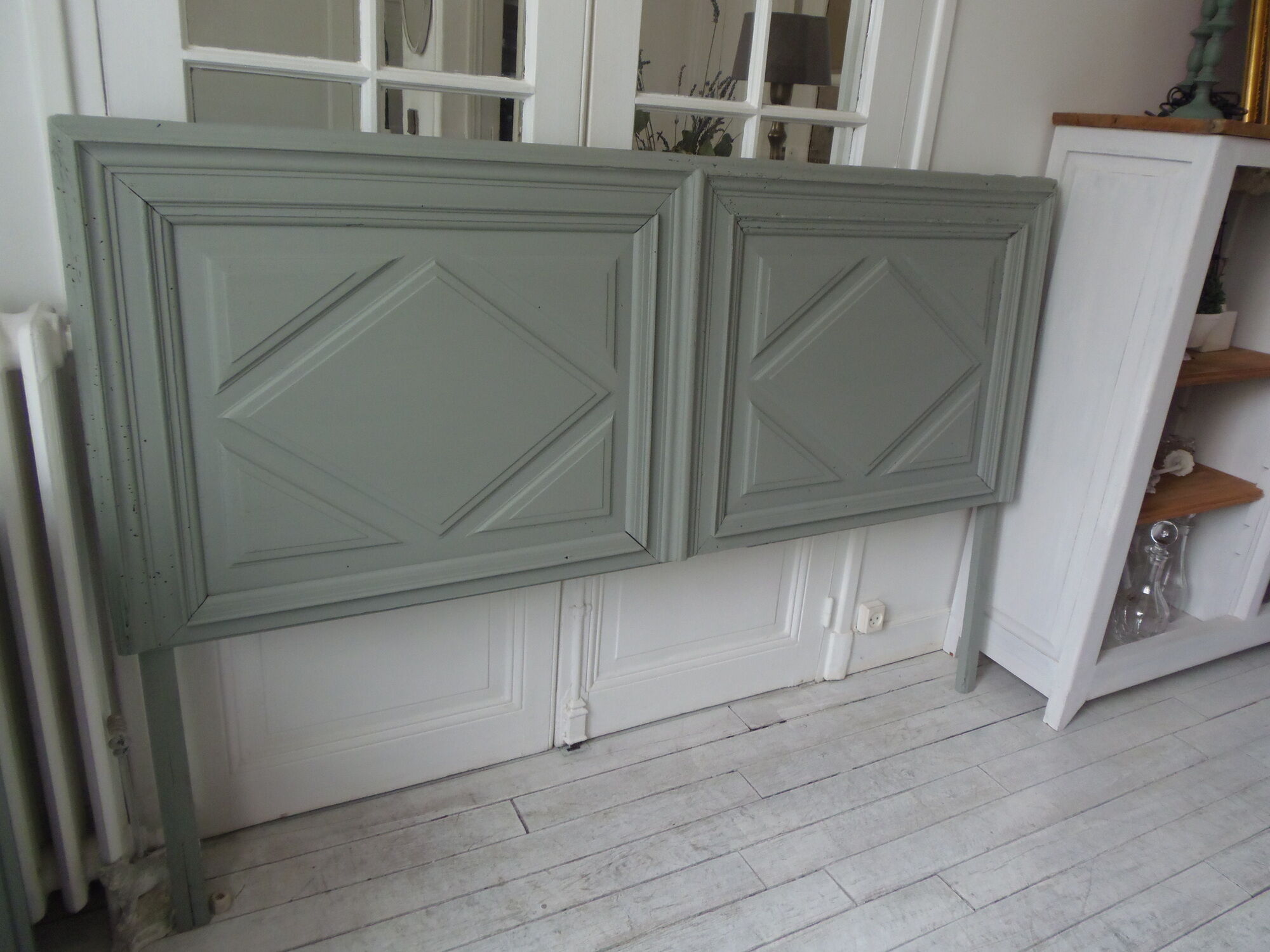 Headboard made with an old walnut door, re-enchanted in gray green waxed finish,