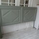 Headboard made with an old walnut door, re-enchanted in gray green waxed finish,