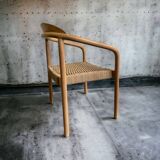 Solid wood chair with woven seat and armrests