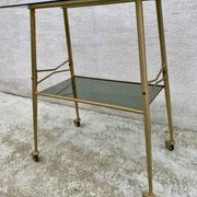 Vintage 1970s glass and gold rolling console table.