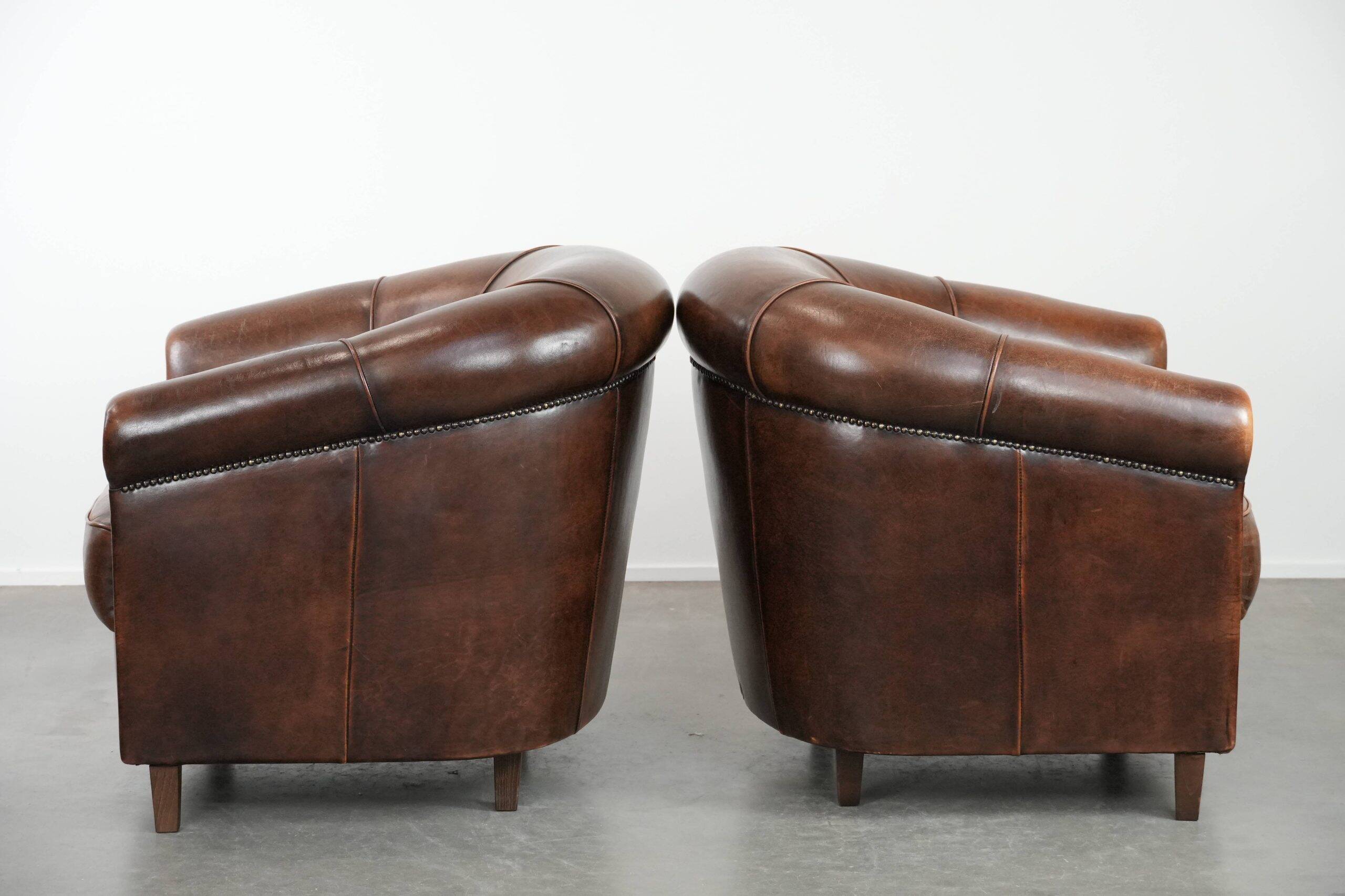 Set of two sheepskin club armchairs with fixed seat cushions