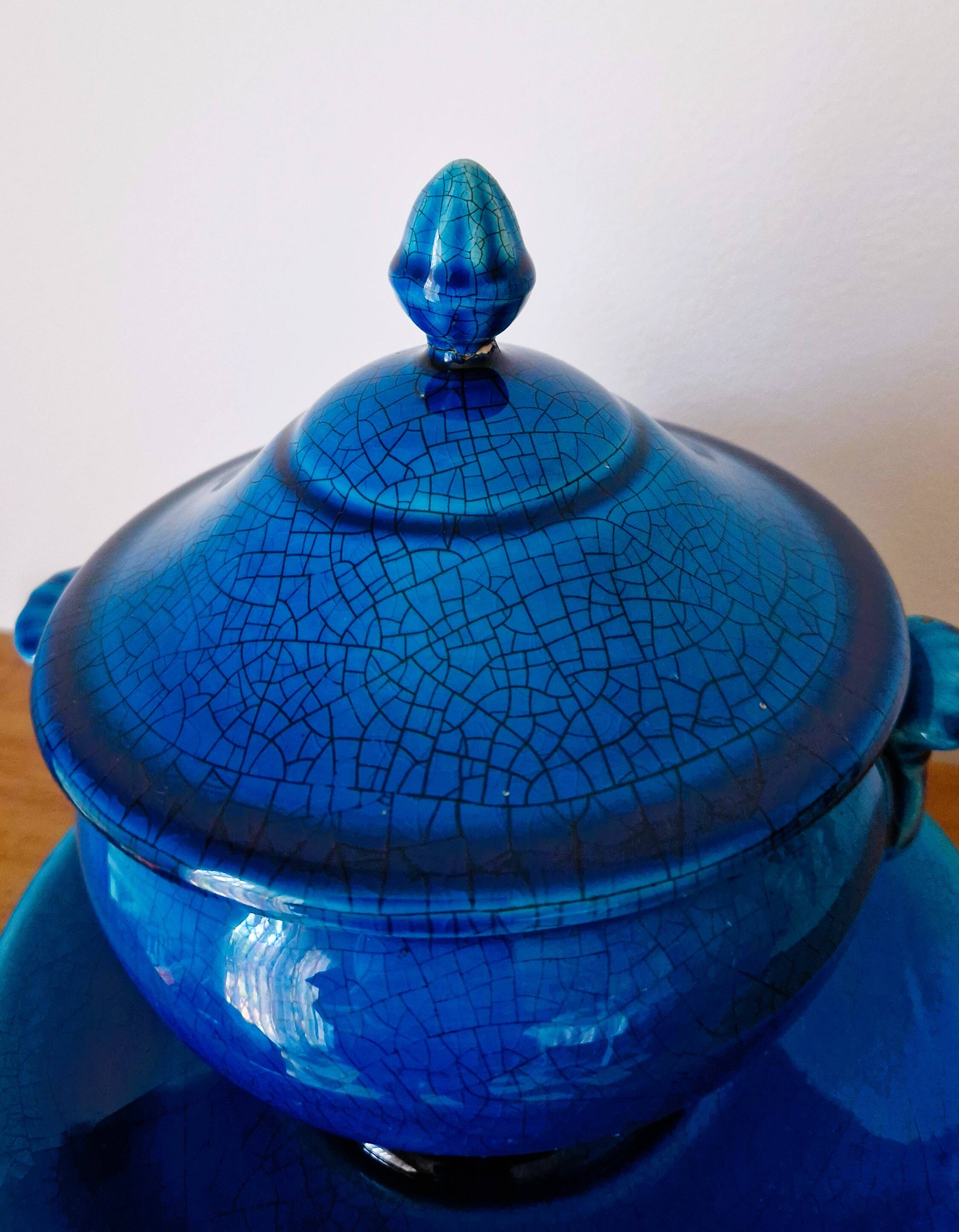 Blue ceramic soup tureen and crackled finish trivet.