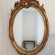 Antique oval mirror in gilded wood with gold leaf – bevelled glass –