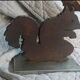Squirrel bookends in rusty metal on a steel base.