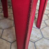 Red leather dining chairs by Arper