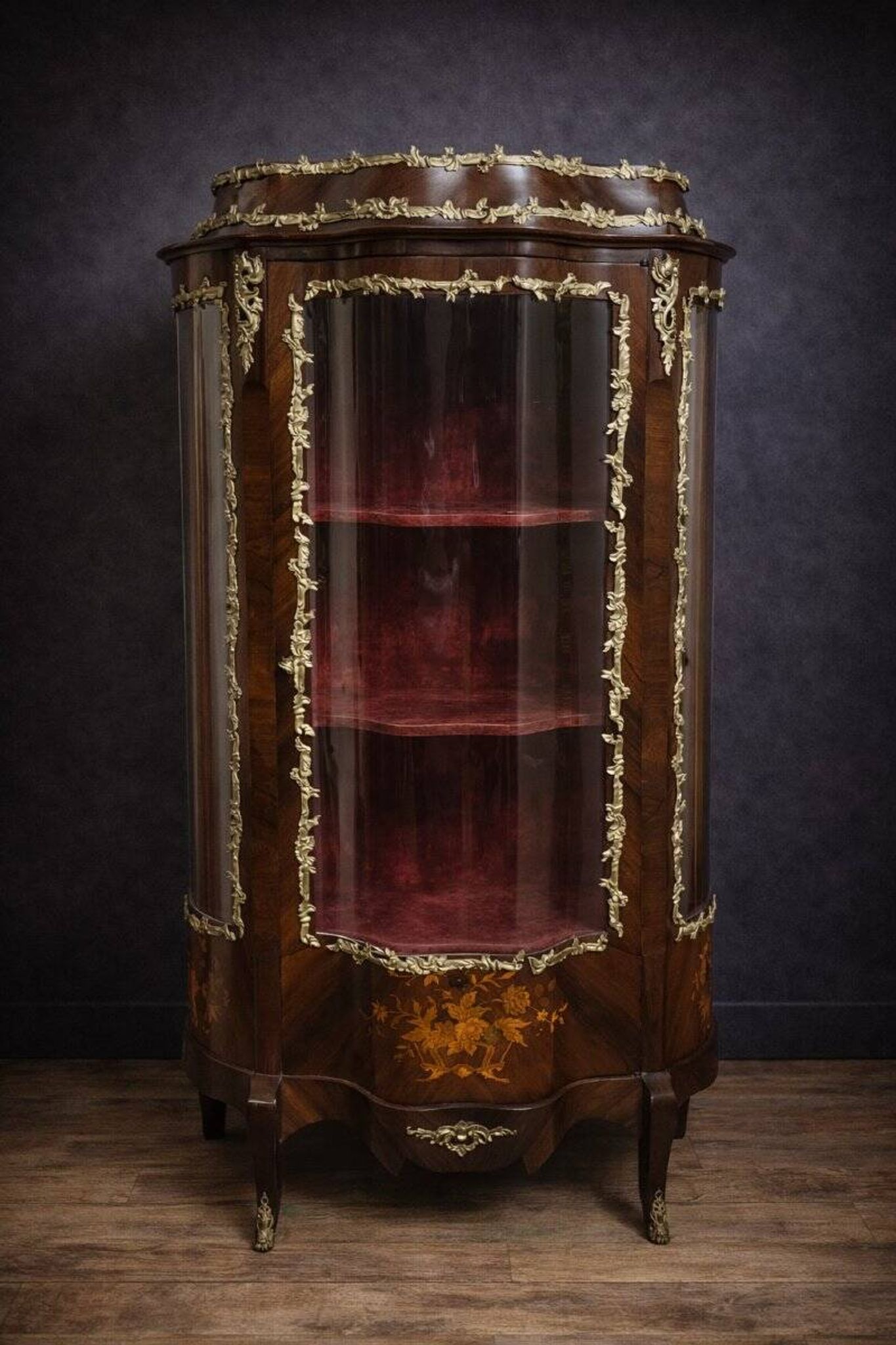 Curved display cabinet in Louis XV style with precious wood marquetry and gilded bronze.
