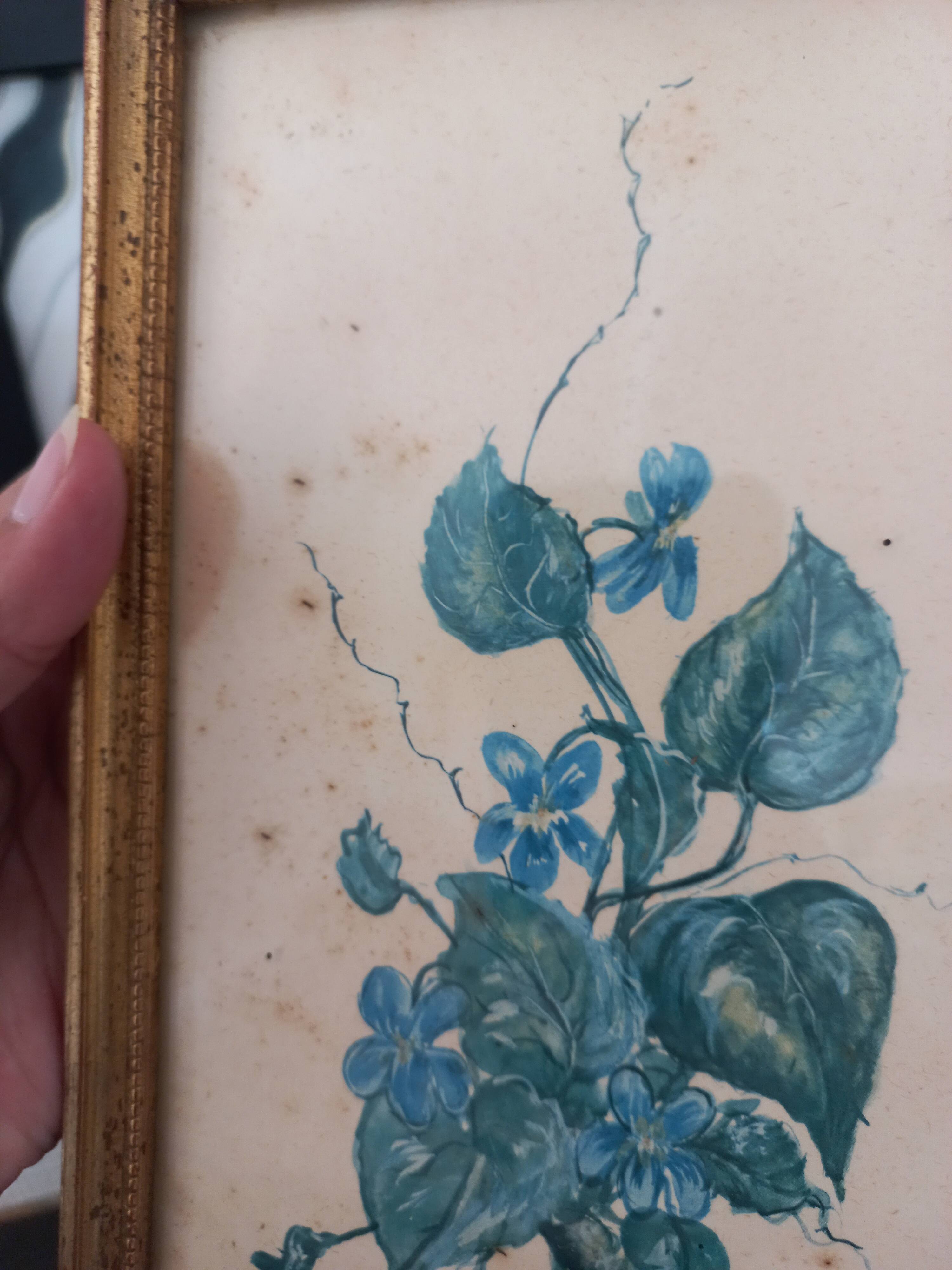 Decorative table with vintage blue flowers in a golden frame.