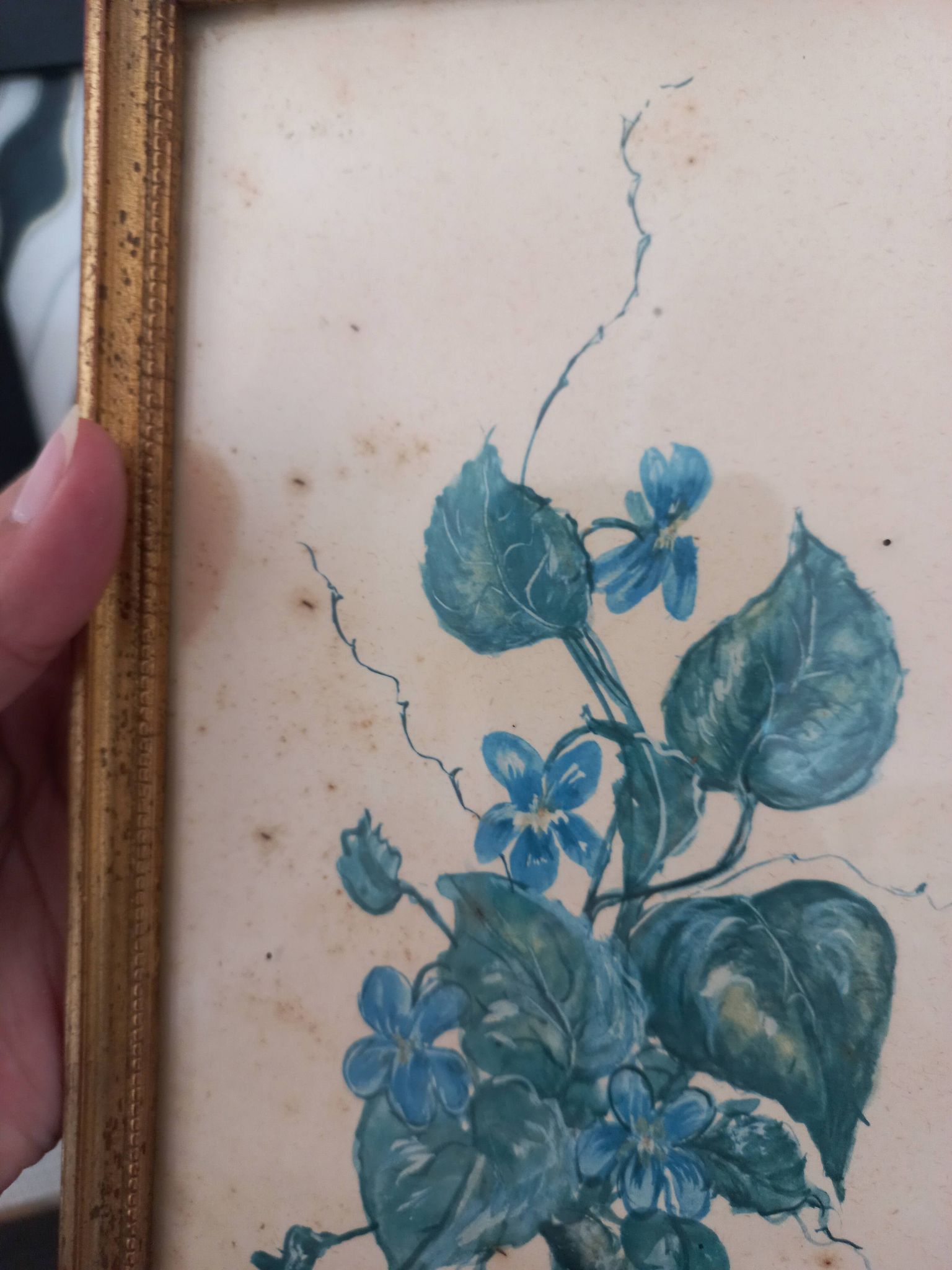 Decorative table with vintage blue flowers in a golden frame.