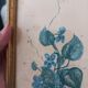 Decorative table with vintage blue flowers in a golden frame.